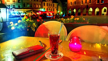  Yaz gecesi sokak kafesi, Tallinn Eski Kasabası 'nda çay masası ve çiçekler, açık romantik restoran, Avrupa' daki Estonya ortaçağ şehrine tatil seyahati.
