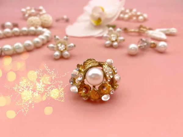 Jewelry gold  white pearl Luxury Glamour fashion  costume jewelry   rings earrings bracelet with  white orchid flower  on  pink coral background women accessories