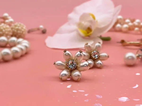 white pearls Jewelry gold  Luxury Glamour fashion  costume jewelry  rings earrings bracelet with white orchid flowers petal  on pink and pink coral background women accessories  set collage
