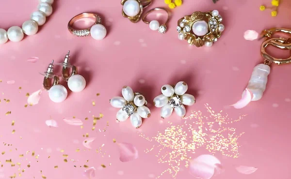 银白色珍珠戒指耳环手镯 粉色背景 白色兰花 女用饰物 — 图库照片