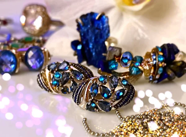白色珍珠和蓝色金银珠宝金蓝色石戒指耳环手镯粉色背景白色兰花手工制造女用饰物 — 图库照片