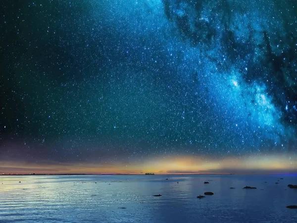 Yıldızlı mavi gece gökyüzü deniz günbatımı arka planında 