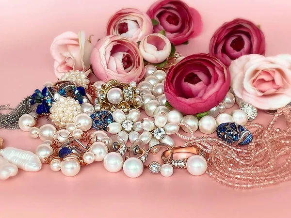 珠宝背景 金白色珍珠戒指耳环手镯粉色带蓝色宝石 红玫瑰花束女配饰时尚花 — 图库照片
