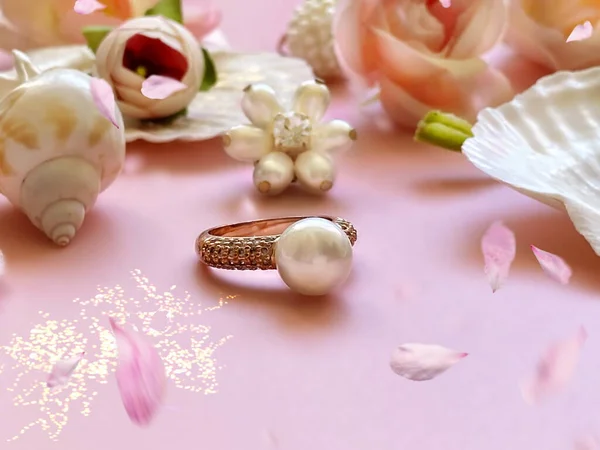 Jewelry gold  white pearl in seashell  Luxury Glamour fashion  costume jewelry ,roses  flowers petal  on blue and pink coral background women accessories fashion ,jewelry handmade, jewelry handicraft manufacturing