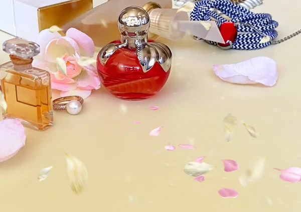 香水瓶のコレクション白を背景に花びらと赤と黄色 — ストック写真