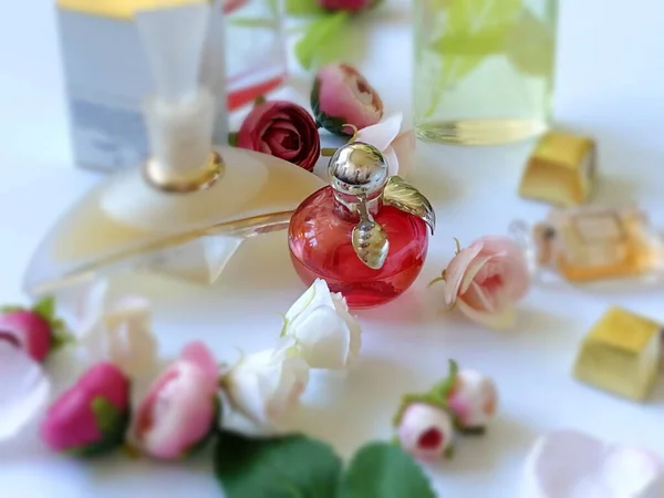 香水ボトルレッドガラス白金の背景に花びら 女性のアクセサリー — ストック写真