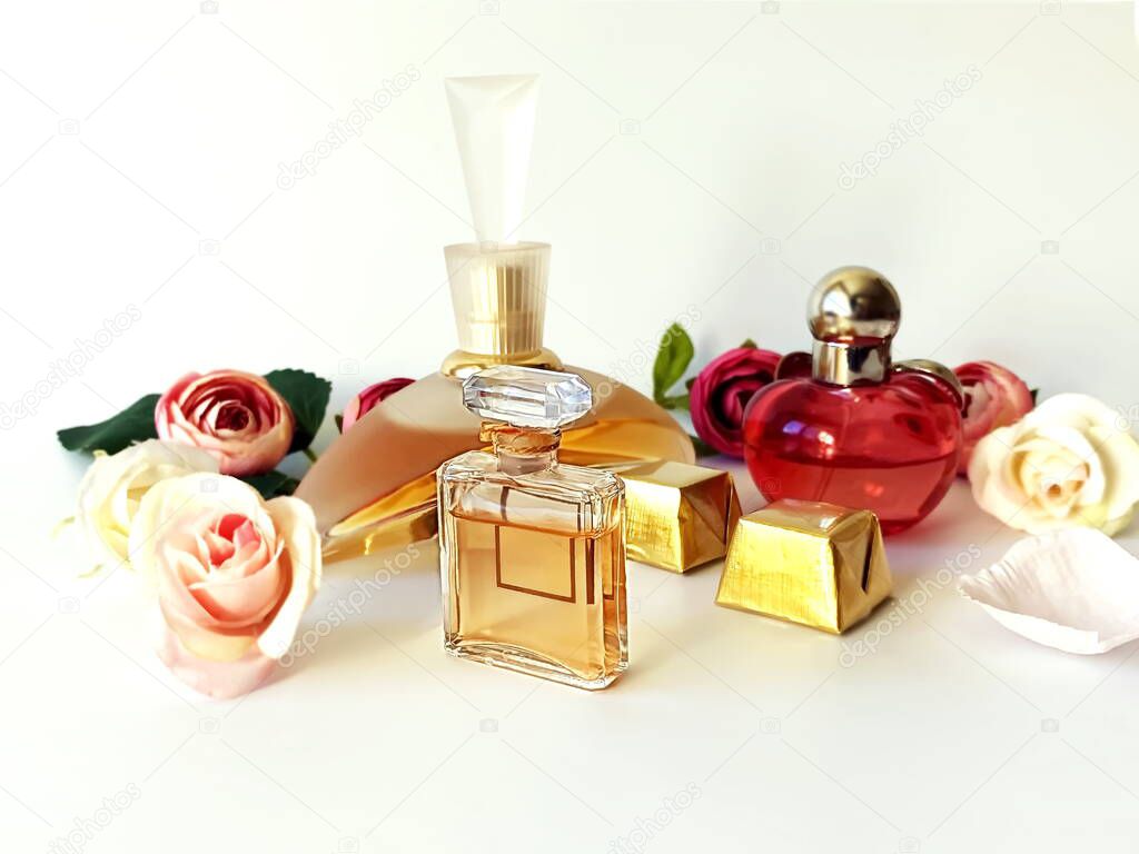 fragrance perfume bottle red  yellow glass   with flowers petal on white gold background ,women accessories floral background ,copy space 