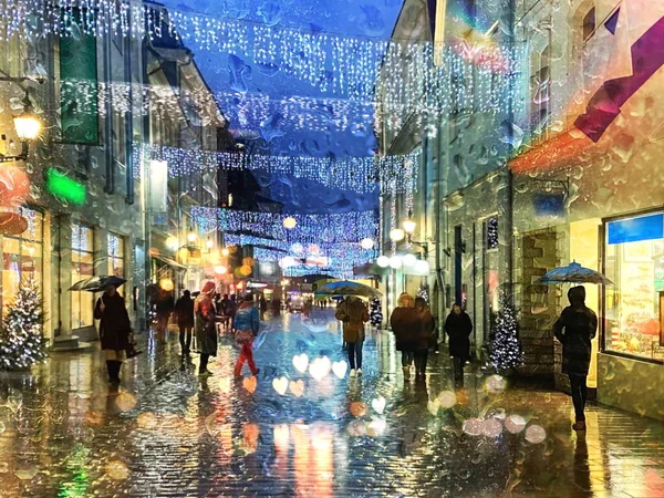 Şehirde yağmurlu bir hava, geceleri Noel caddesi şemsiyelerle yürüyen insanlar, pencerelere yansıyan yağmur damlaları ıslak asfalt üzerinde bulanık ışık Tallinn 'e giden eski kasabaya giden yol. 