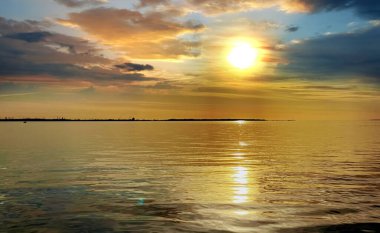 Deniz batımında pembe altın sarısı güneş ışığı deniz suyunun yansıması deniz kabuğu bulutları güzel gökyüzü güneş ışığı arka planı 