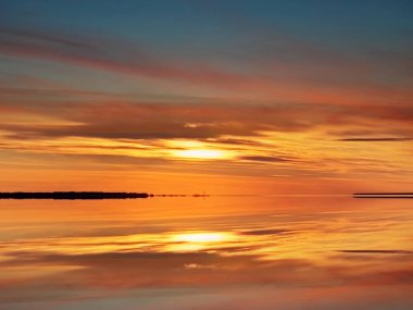  Deniz altında gün batımı. Pembe bulutlu gökyüzü. Ufukta turuncu gökyüzü. Ufukta deniz kabuğu. 