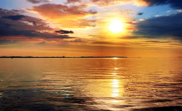 Deniz altında gün batımı. Pembe bulutlu gökyüzü. Ufukta turuncu gökyüzü. Ufukta deniz kabuğu. 