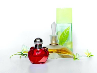 Parfüm şişesi pembe arka planda çiçek yaprağı, kadın aksesuarları.