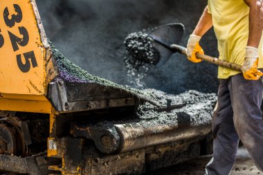 asfalt yeni işçilerle birlikte araçlarla döşenir