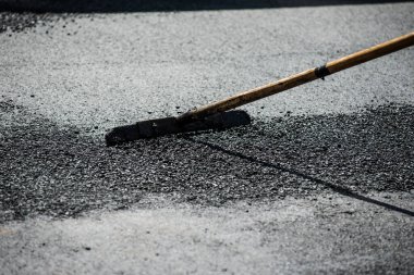 asfalt yeni işçilerle birlikte araçlarla döşenir