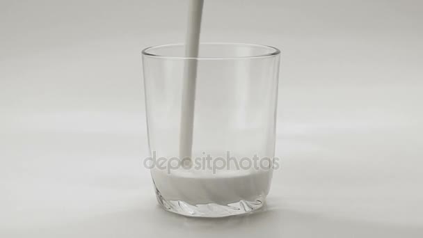Despejando iogurte branco em vidro transparente no fundo branco — Vídeo de Stock