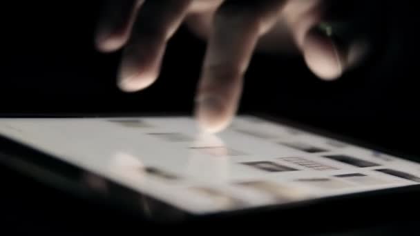 Просмотр фотоленты на планшетном компьютере в темноте — стоковое видео