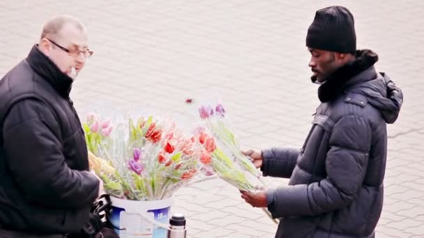 Černoch si koupí květiny od pouličního prodejce — Stock video