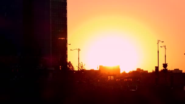 A naplemente, a háttérben a kontrasztos formák, a városi épületek — Stock videók
