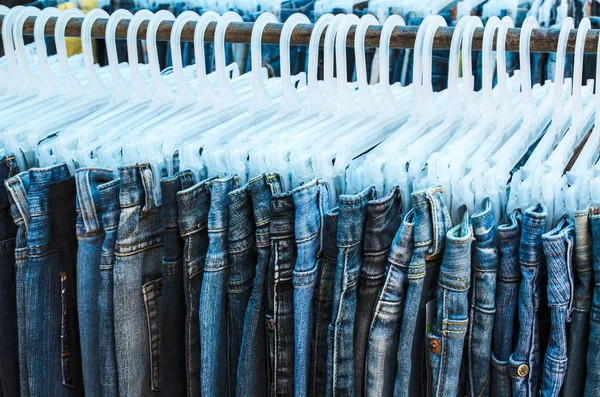 Reihe von Jeans und Hosen auf Kleiderbügeln zum Verkauf — Stockfoto