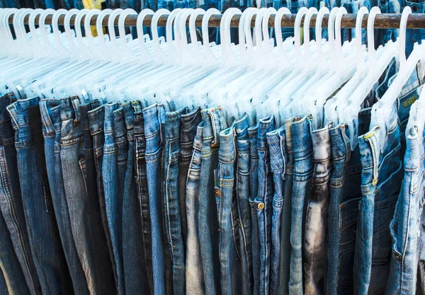 Reihe von Jeans und Hosen auf Kleiderbügeln zum Verkauf — Stockfoto