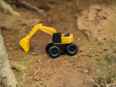 Oyuncak inşaat makineleri bir kazı üzerinde çalışıyor