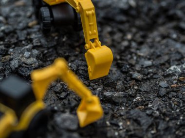 Oyuncak inşaat makineleri bir kazı üzerinde çalışıyor