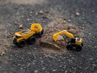 Oyuncak inşaat makineleri bir kazı üzerinde çalışıyor