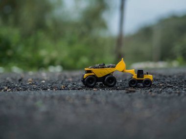 Oyuncak inşaat makineleri bir kazı üzerinde çalışıyor