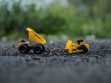 Oyuncak inşaat makineleri bir kazı üzerinde çalışıyor