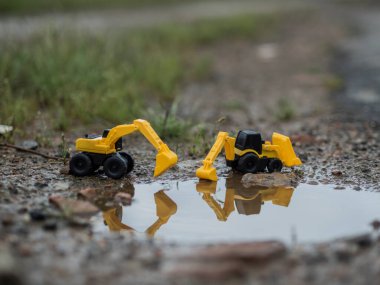 Oyuncak inşaat makineleri bir kazı üzerinde çalışıyor