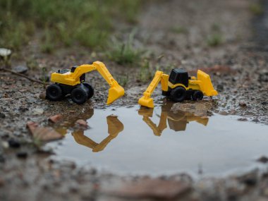 Oyuncak inşaat makineleri bir kazı üzerinde çalışıyor