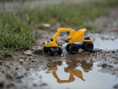 Oyuncak inşaat makineleri bir kazı üzerinde çalışıyor