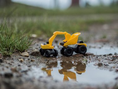 Oyuncak inşaat makineleri bir kazı üzerinde çalışıyor