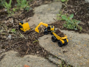 Oyuncak inşaat makineleri bir kazı üzerinde çalışıyor