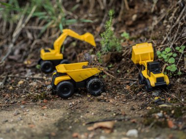 Oyuncak inşaat makineleri bir kazı üzerinde çalışıyor