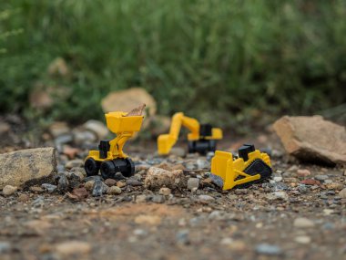 Oyuncak inşaat makineleri bir kazı üzerinde çalışıyor