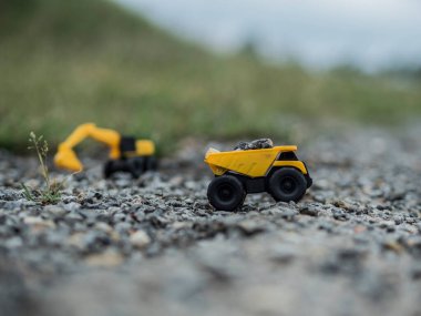 Oyuncak inşaat makineleri bir kazı üzerinde çalışıyor