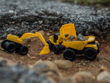Oyuncak inşaat makineleri bir kazı üzerinde çalışıyor