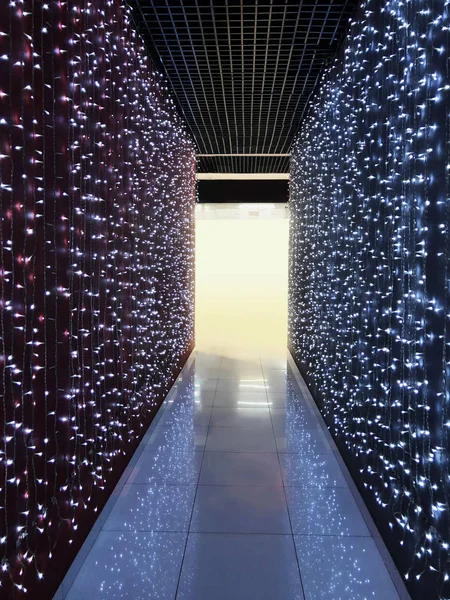Corridor illuminated by many light bulbs.