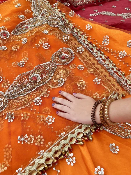 La mano femenina toca la tela india de color naranja . —  Fotos de Stock