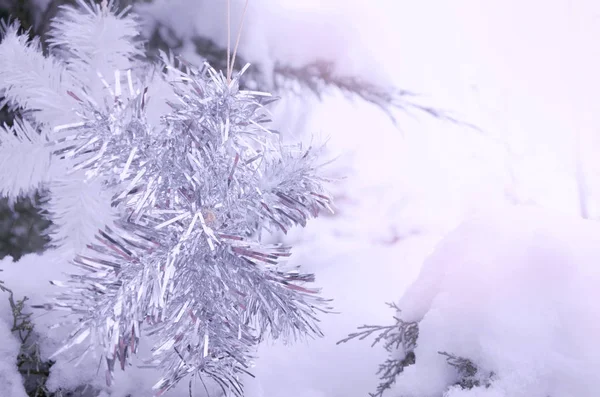 Flocons de neige de tinsel sur les branches enneigées d'un arbre de Noël — Photo