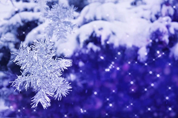 Snowflakes from Christmas tinsel on a background of a winter for — Stock Photo, Image