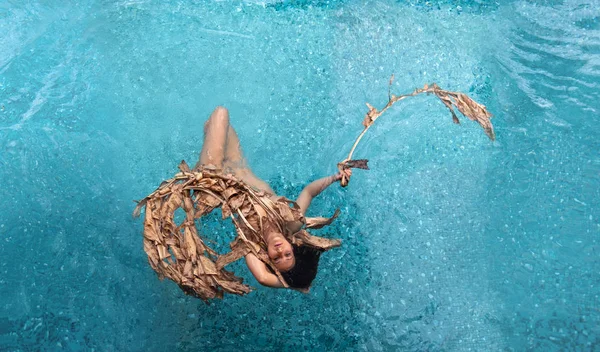 Κάτοψη μιας όμορφης νεαρής σέξι γυναίκας που επιπλέει χαλαρή σε αποξηραμένα φύλλα μπανάνας, μπλε νερό στην πισίνα, αντιγραφή χώρου — Φωτογραφία Αρχείου