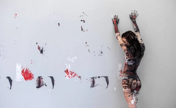 Femme en sous-vêtements, vêtements de sport, jeune et sexy, artistiquement abstraite peinte avec du noir, rouge, blanc, peinture, rouleaux devant le mur en studio et laisse des impressions colorées, espace de copie . — Photo