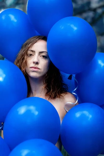 Retrato de una joven en medio de un montón de globos azules —  Fotos de Stock