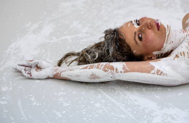 Koyu kahverengi saçlı, beyaz renkli dekoratif bir kadının portresi. Yaratıcı dışavurumcu soyut vücut boyama, makyaj, boşluk kopyalama.