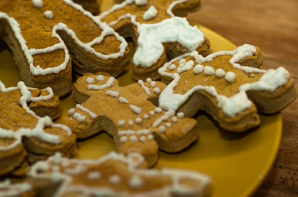 クリスマスの時間 プレート上のジンジャーブレッドクリスマスクッキーを選択する子供の手の詳細 — ストック写真