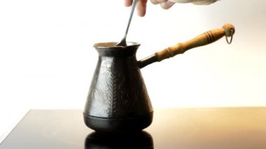 Kadın elektro sobanın üstünde kahve demliyor. Türk kahvesi, lezzetli bir aroma. Beyaz arkaplan.