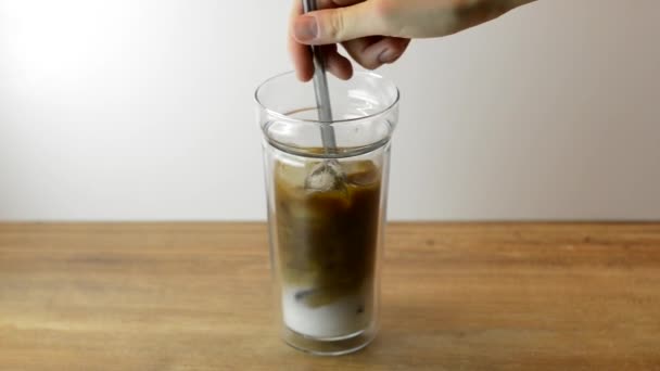 冷たいビールアイスコーヒーのグラスに牛乳を攪拌女性 アイスコーヒーを作る — ストック動画