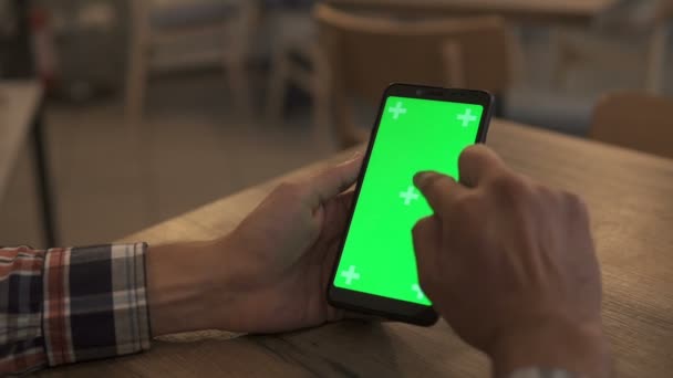 Közelkép egy Mans Hand Holding Green Mock Screen Smartphone-ról. Alkalmazás használata. Modern mobiltelefon. A háttérben Hangulatos nappali vagy Home Office. — Stock videók